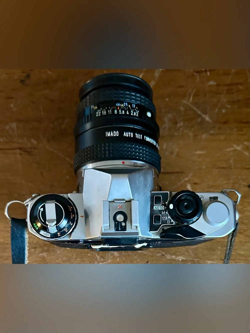 Pentax Silver and Black SLR Camera with Black Lens Cap and Colorful Strap